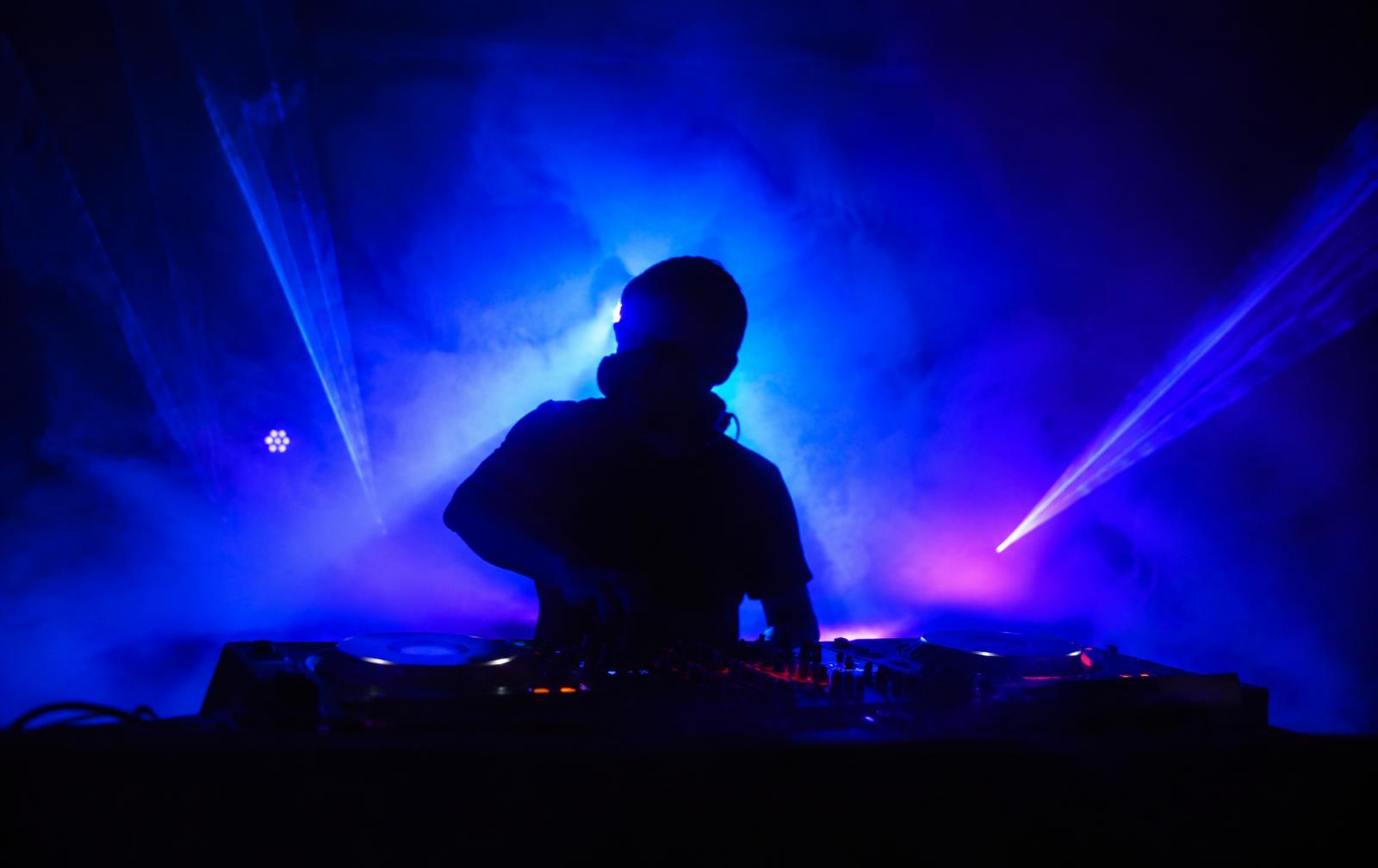 DJ Khari performing under neon lights